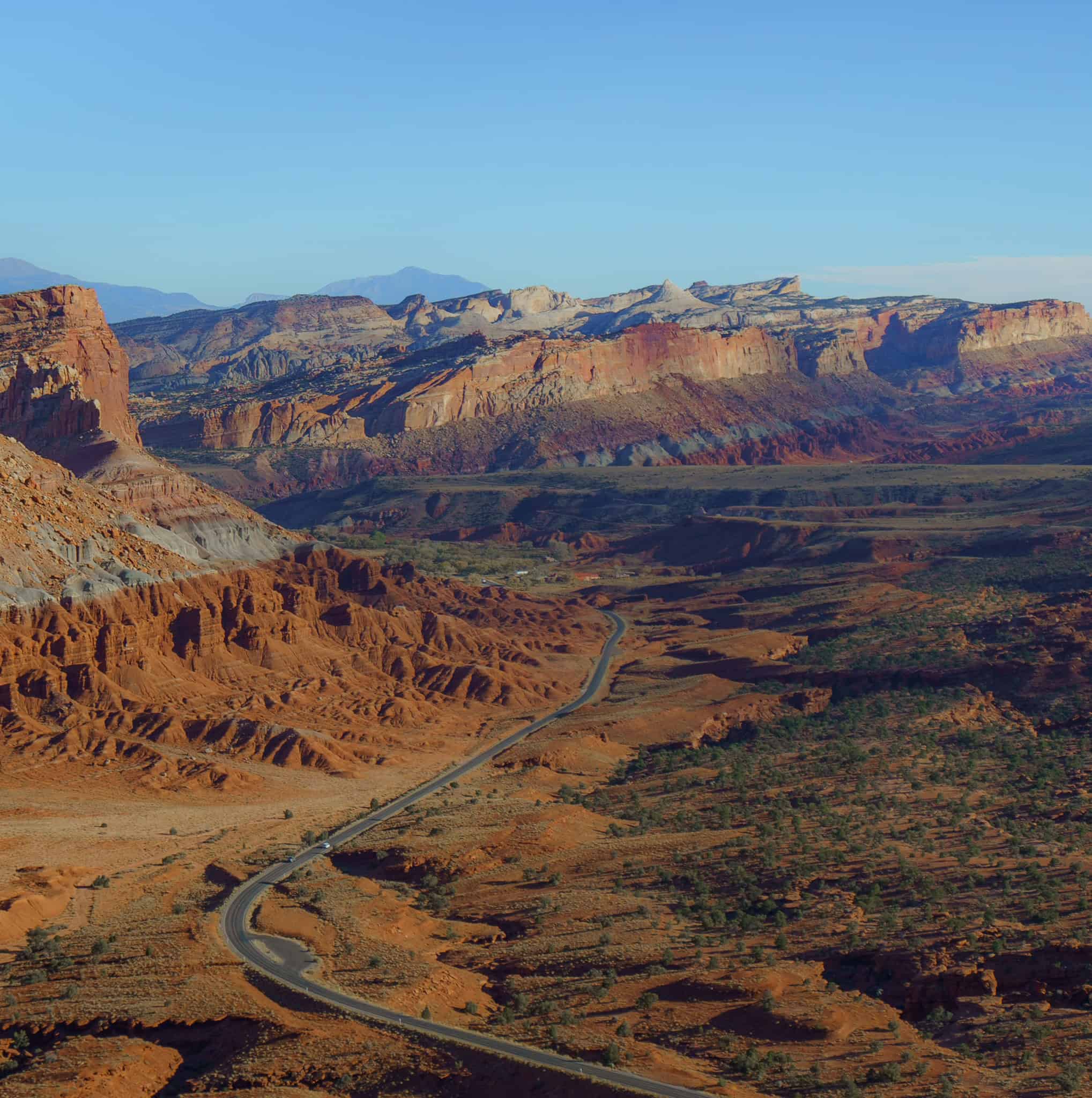 Aerial view of a road surrounded by beautiful red and orange desert scape in Capitol Reef National Park, Utah. 