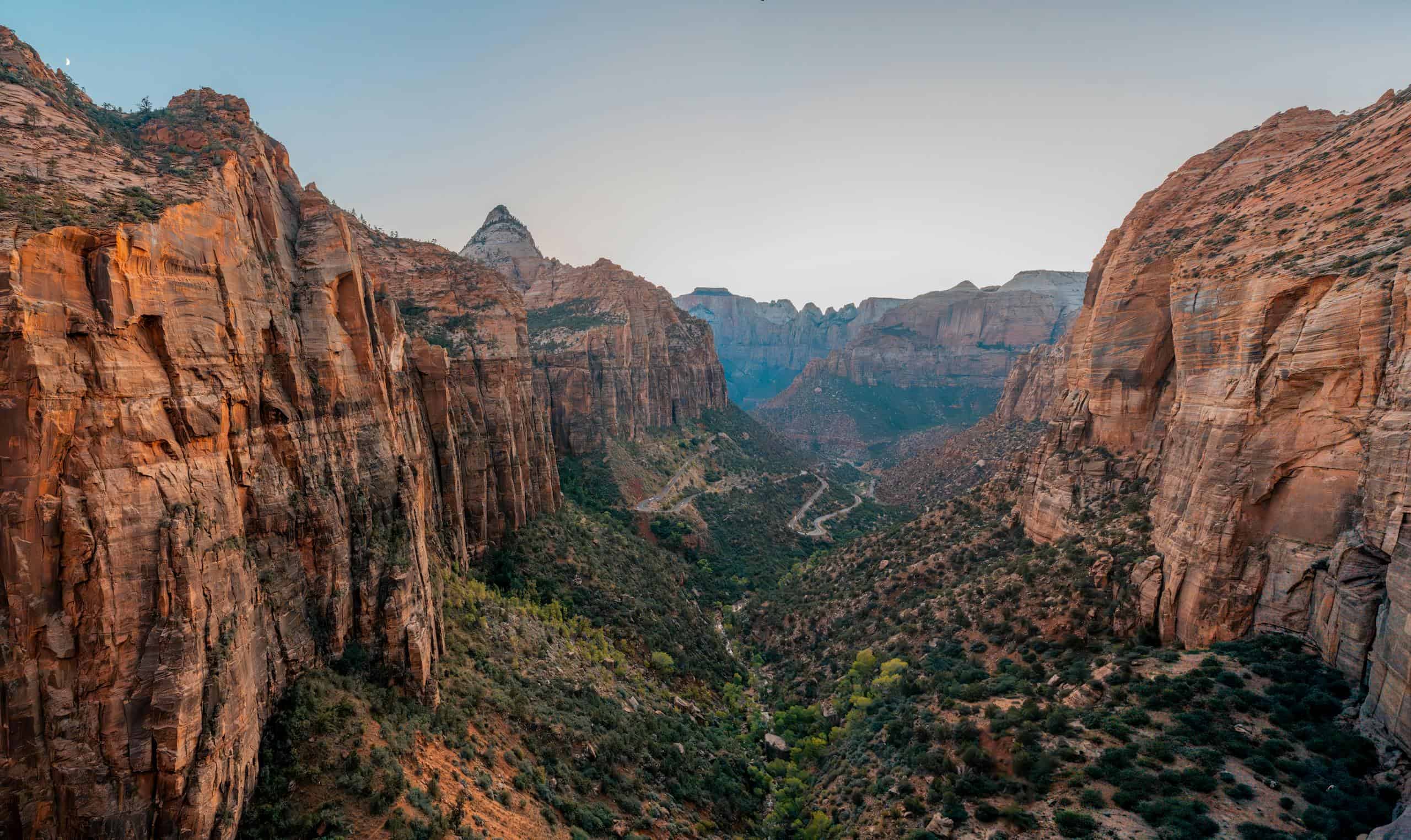 Breathtaking view of Zion Canyon under the morning light, showcasing its dramatic rock formations and lush valleys.
