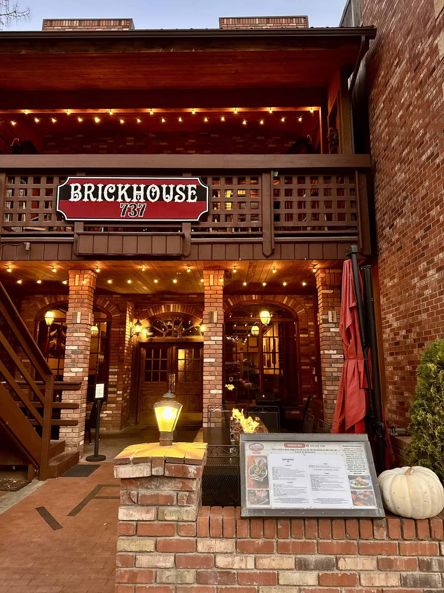 A warmly lit brick restaurant with string lights and a cozy outdoor seating area, showcasing one of the appealing dining options in Ouray.