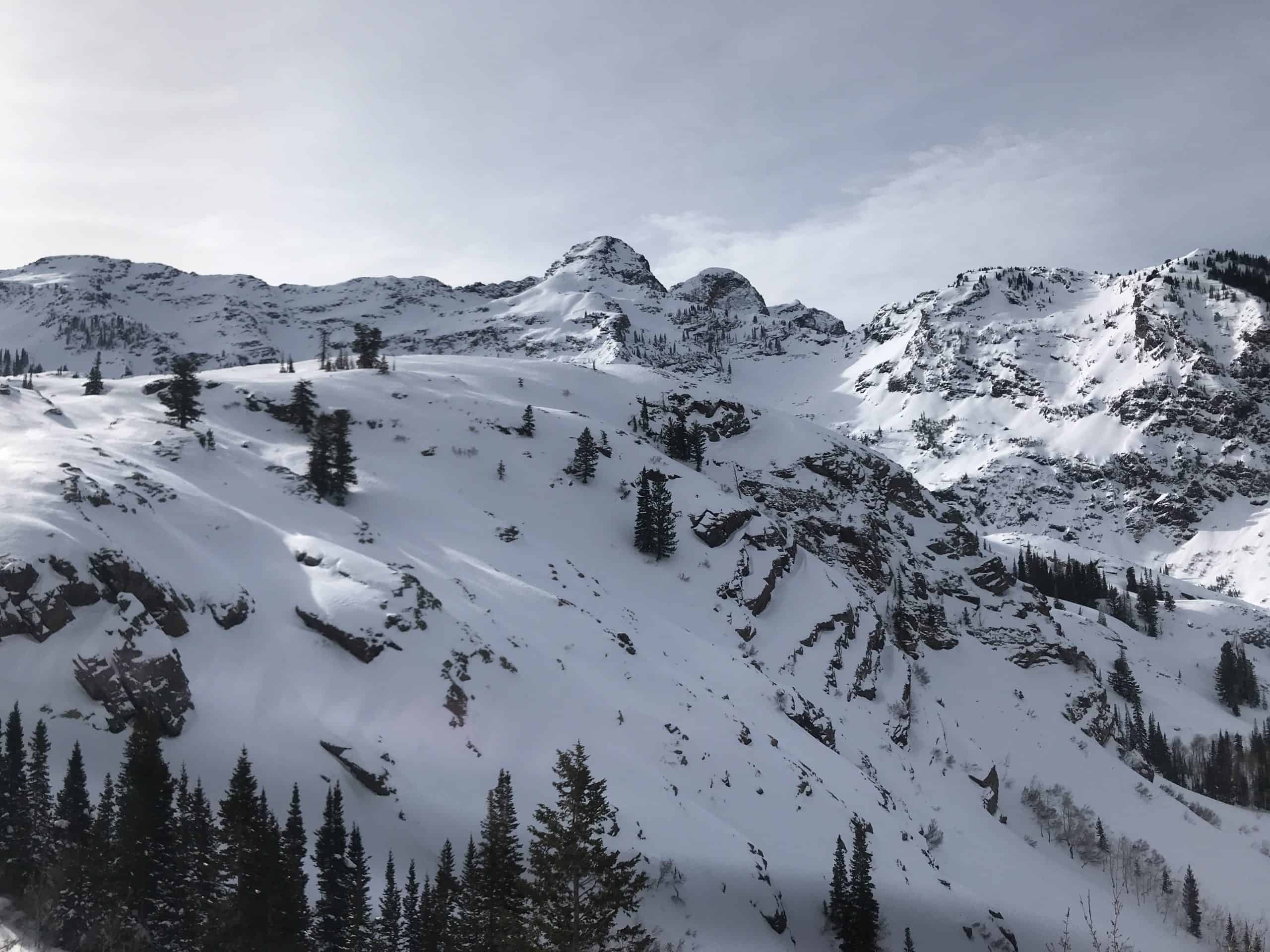 A stunning snow-covered mountain landscape featuring Dromedary and Sunrise Peaks, as viewed from the Lake Blanche Trail.