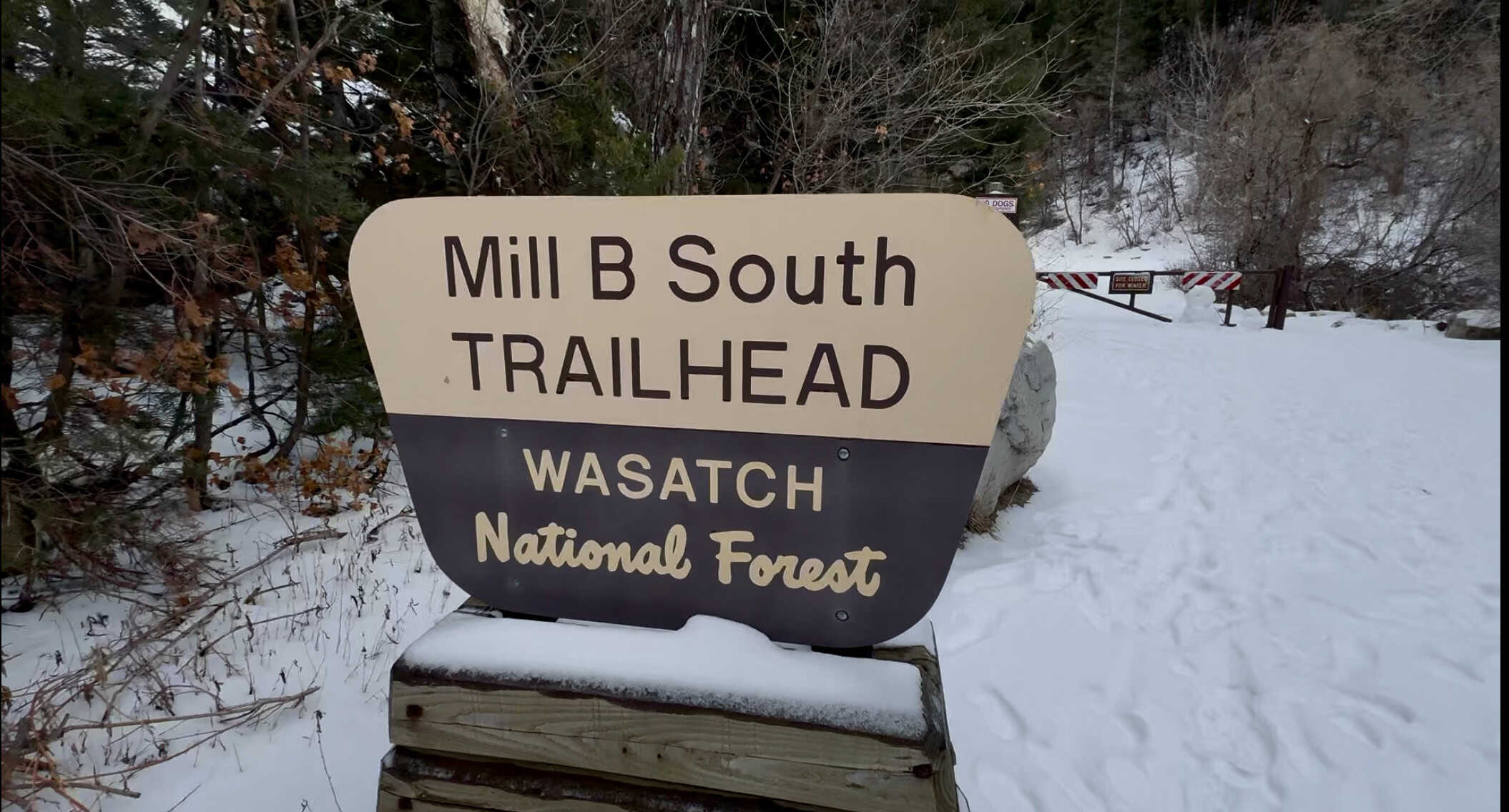 A snowy trail sign at the Mill B South Trailhead in the Wasatch National Forest, marking the start of the Lake Blanche Trail and Broads Fork Trail.