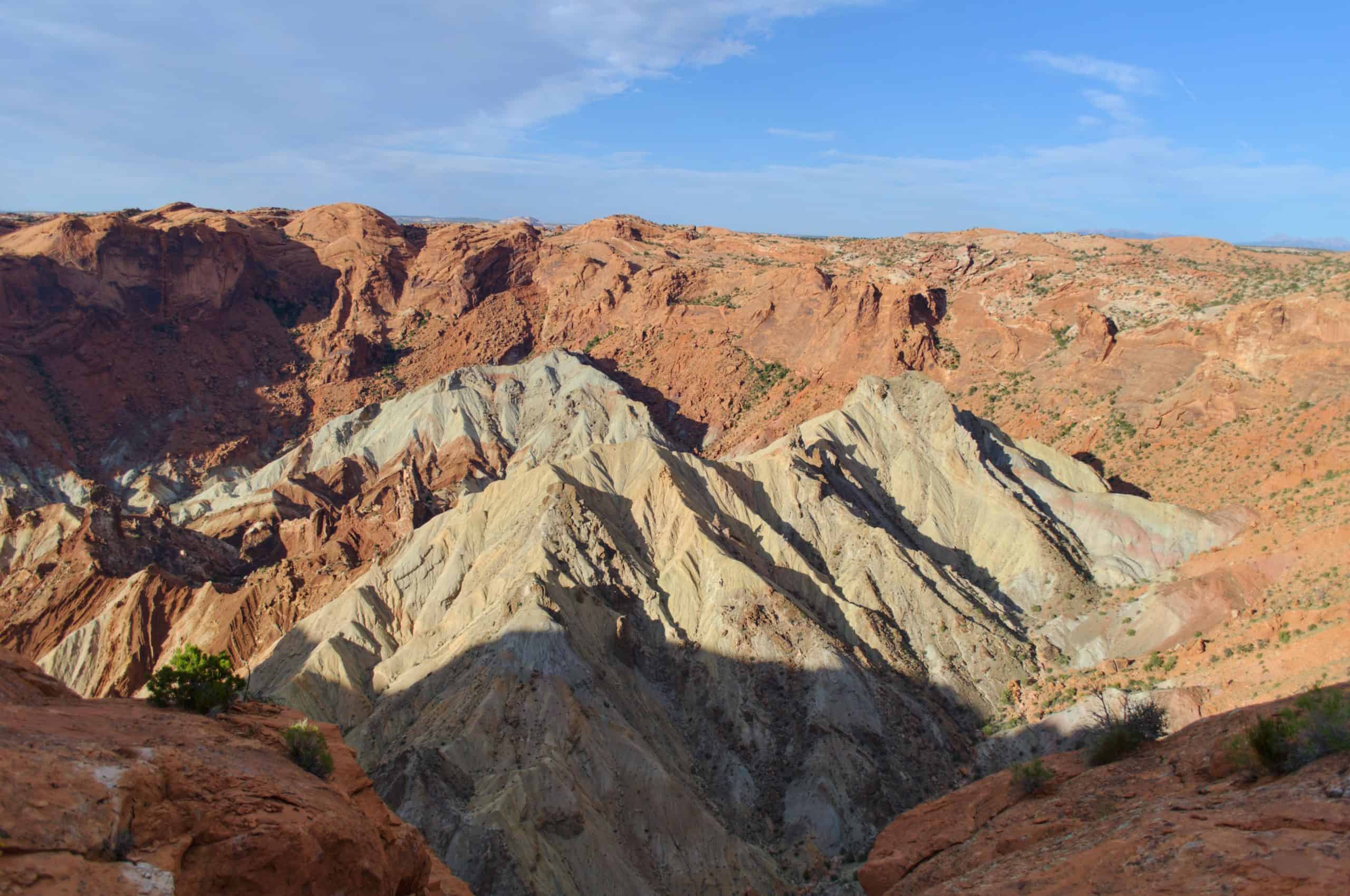 A dramatic view of the multicolored rock layers and deep canyons of Upheaval Dome. capturing the stunning geology you’ll discover while hiking in Canyonlands National Park.