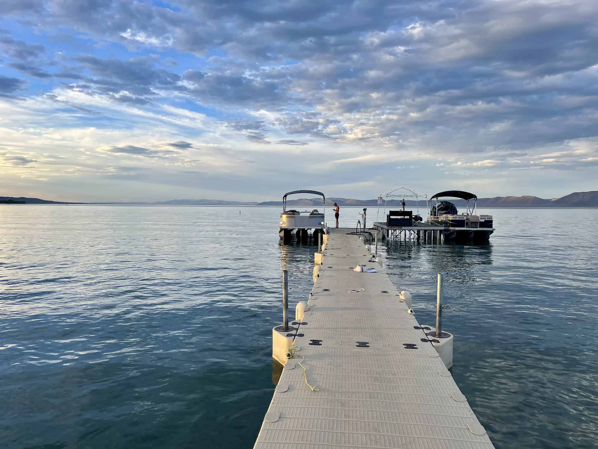A serene view from Rendezvous Beach Pier on a calm evening, with boats docked and the vast waters of Bear Lake stretching into the distance